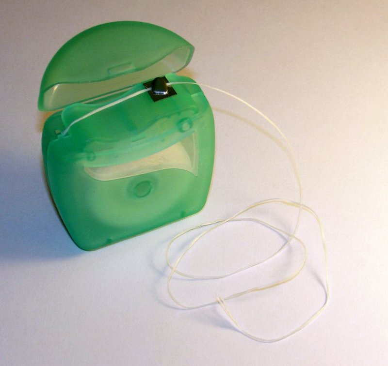 Roll of dental floss, one of the six habits in a realistic daily routine for a healthier oral microbiome
